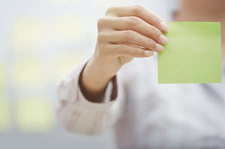 Woman holding sticky note with empty spaceの写真素材