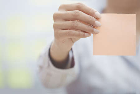 Woman holding sticky note with empty spaceの写真素材