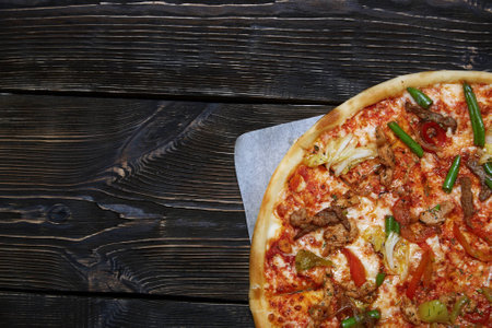 Part of homemade pizza on a wooden tableの写真素材