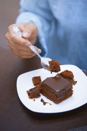 Hand of woman eating chocolate cake の写真素材