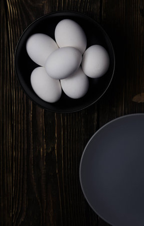 Chicken eggs in plate on a wooden tableの写真素材
