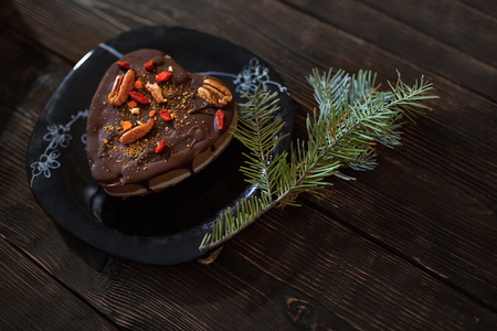Gluten and dairy free chocolate cake with Christmas tree twig on a wooden tableの写真素材