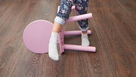 Legs of the child overstepping chair for balance skill developmentの写真素材