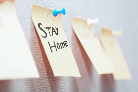Adhesive note with Stay Home text on a bulletin boardの写真素材