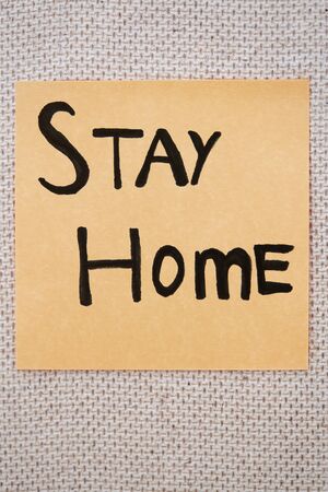 Adhesive note with Stay Home text on a bulletin boardの写真素材
