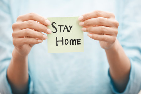 Woman holding adhesive note with Stay Home textの写真素材