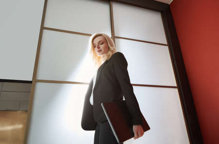 Young adult business woman wearing formalwear and carrying the laptopの写真素材
