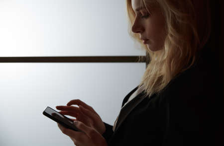 Young adult woman using smartphone at the officeの写真素材