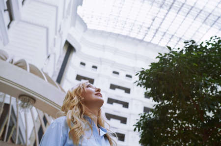Businesswoman in the modern bank lobby looking upの写真素材