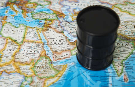 Oil drum with crude petroleum standing on a mapの写真素材