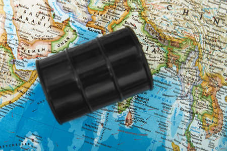Oil drum with crude petroleum lying down on a mapの写真素材