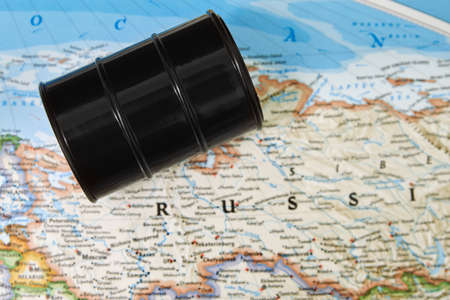 Oil drum with crude petroleum lying on a mapの写真素材