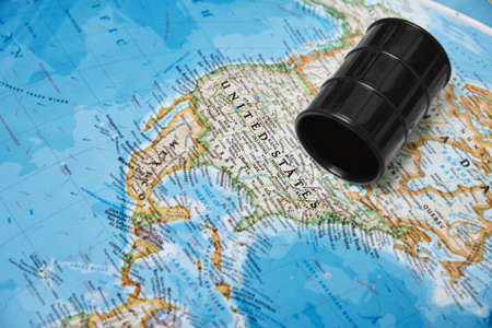 Oil drum with crude petroleum lying on a mapの写真素材