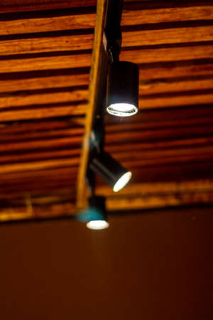 A vertical closeup shot of a pair of LED lights on a wooden wall