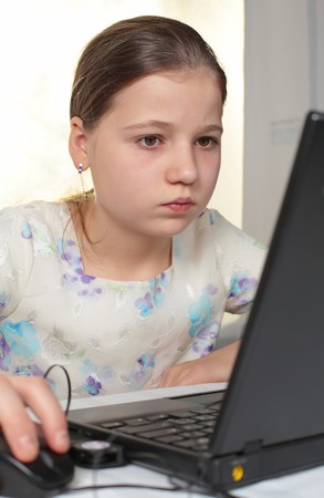 Teenage girl 12-13 years old using laptop computerの写真素材