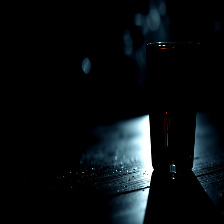 Glass on a wooden table in the dark. Selective focus.の写真素材