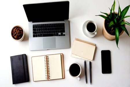 Laptop, coffee cup, notebook and phone on white background.