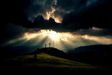 Sunset in the mountains with a cross in the foreground and clouds