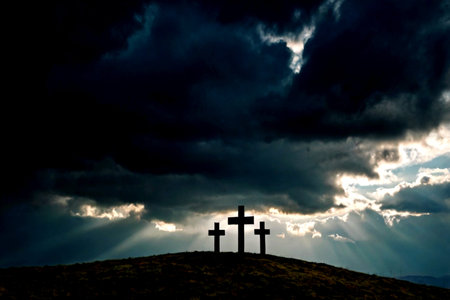 Crosses on the hill at sunset with dramatic sky and sun raysの写真素材
