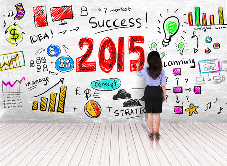 business woman drawing step of success in year 2015 on white wall