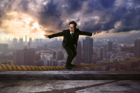 business man is keeping balance on the ropeの写真素材