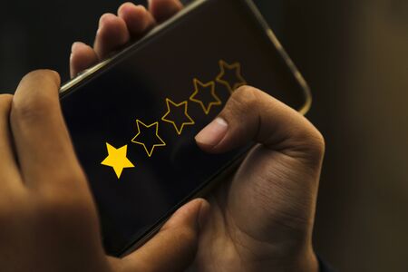 attractive hands giving one star rating on a smart phone