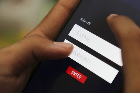 attractive hands writing sign username on a smart phoneの写真素材