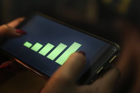 hands showing profit graph on a smart phoneの写真素材