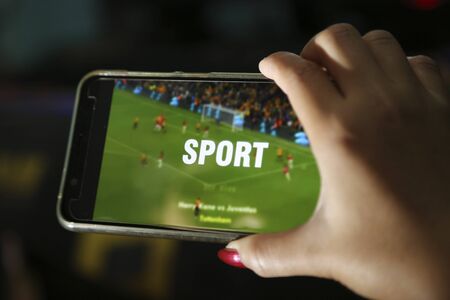 hands showing sport video on a smart phoneの写真素材