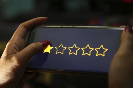hands showing one stars on a smart phoneの写真素材
