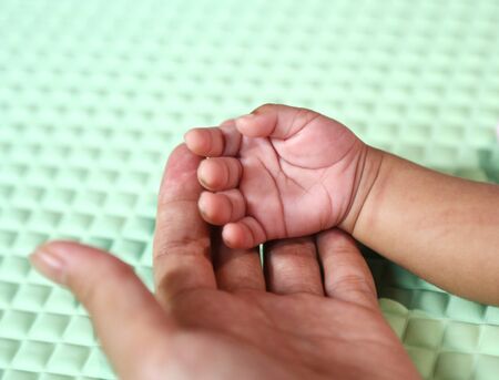 mother hand holding her baby handの写真素材