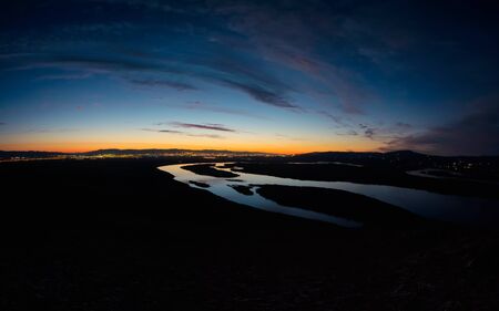 Light of the city at night on a background of a winding riverの写真素材