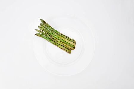 Grilled asparagus on glass plate, on a white backgroundの写真素材