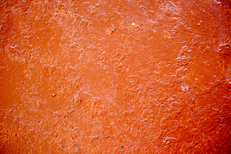 Old cracked wall painted with orange paintの写真素材