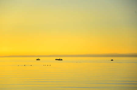 Beautiful Golden sunset, the fishermen go for fishing in deep lake Baikalの写真素材