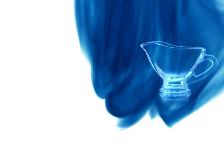 Empty glass bowl on white background enveloped in puff of blue smoke.の写真素材
