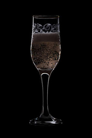 Patterned flute with champagne with bubbles isolated on black background.の写真素材