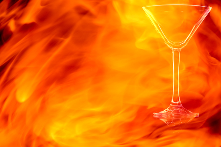 Empty cocktail glass isolated on black background in the fire flames.の写真素材