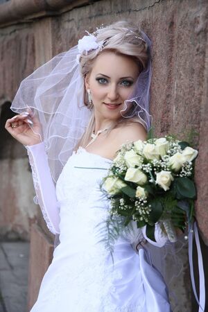 bride with  wedding bouquet Against  stone wall の写真素材