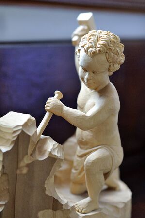 wooden carved figure of a child workerの写真素材