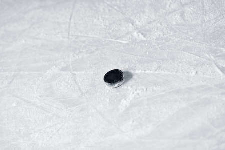 Hockey puck on the surface of ice rinkの写真素材