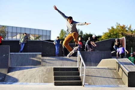 Boy high jumps on a skateboard on the railingの写真素材