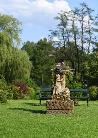 Green garden park with stone statueの写真素材