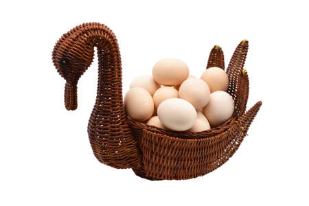 Chicken eggs in a wicker basket isolated on a white background.の写真素材