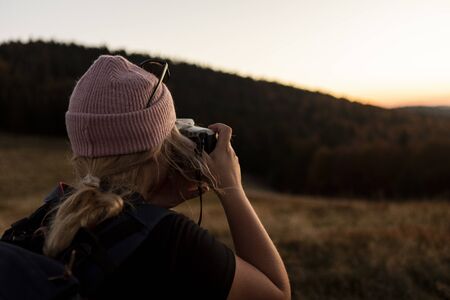 Portrait of beautiful young woman whos relax in mountains. girl takes pictures by camera.の写真素材