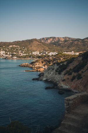 Hilly coast of Majorca. in the background a small village situated by the sea. summer scenery. Selective focusの写真素材