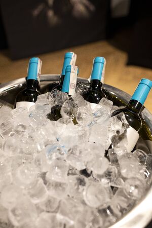 Bottles of champagne in cooler. Bottles in bucket of ice in the foreground. Selective focusの写真素材