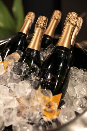 Bottles of champagne in cooler. Bottles in bucket of ice in the foreground. Selective focusの写真素材