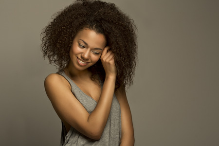 Portrait of a beautiful natural young African afro woman smiling happinessの写真素材