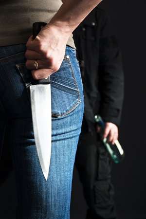 Woman with a knife facing her drunk husband. の写真素材